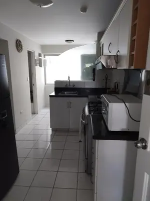 a white kitchen with a sink and a stove at Residencial Pardo in Lima