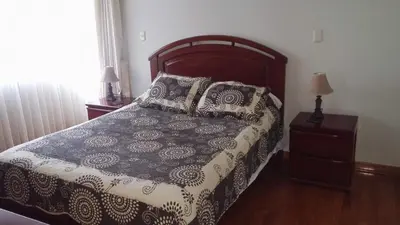 a bedroom with a bed with a black and white comforter at Residencial Pardo in Lima