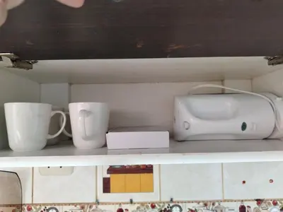 a shelf with cups and a printer on it at Apartamento acogedor en La Perla in Lima