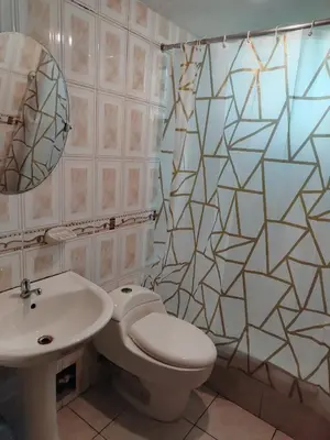 a bathroom with a toilet and a sink and a mirror at Apartamento acogedor en La Perla in Lima