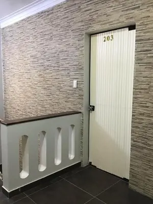 a door in a room with a brick wall at Hernandez suites Suite203 in Lima