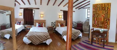 a bedroom with two beds and a mirror at Tika bungalows hotel in Ollantaytambo