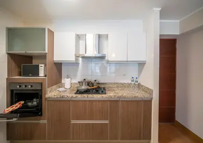 a kitchen with white cabinets and a counter top at Luxury Flat Miraflores Pool Gym Fast WiFi Balcony in Lima