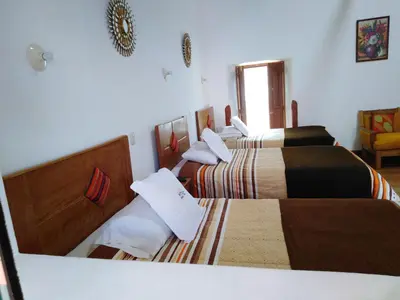 a room with three beds in a room at Casa San Pedro Cusco in Cusco