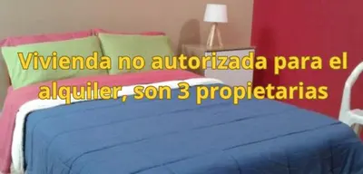 a bedroom with a blue bed with a red wall at Hermanas Pimentel in Ica