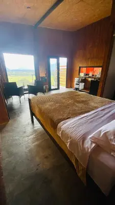 a bedroom with a large bed and a living room at Vista al valle in Oxapampa