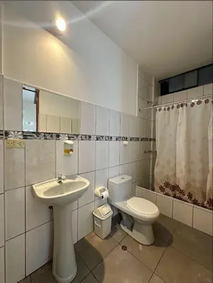 a bathroom with a sink and a toilet and a sink at Hostal El Rey in Lima