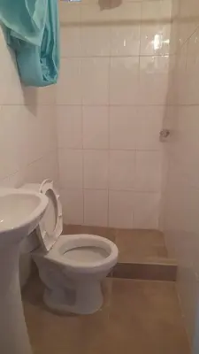 a bathroom with a white toilet and a sink at EcoLodge Mayu Camping in Cusco