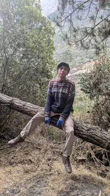 a young man sitting on a tree branch at EcoLodge Mayu Camping in Cusco