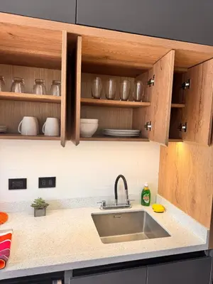 a kitchen counter with a sink and wooden cabinets at betoben in Lima