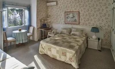 a bedroom with a bed and a table and chairs at B&B El Olivar in Lima