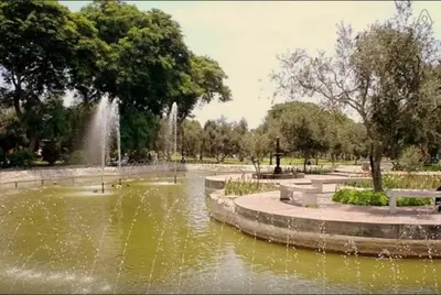 a park with a pond with a fountain in it at B&B El Olivar in Lima