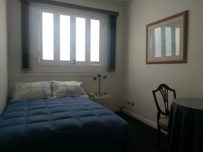 a bedroom with a blue bed and a window at B&B El Olivar in Lima