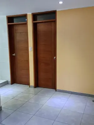 two wooden doors in a room with a tile floor at Hermoso Departamento en Pueblo Libre in Lima