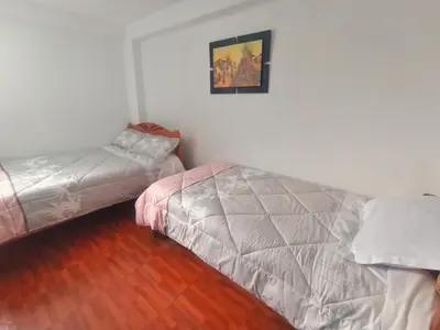 a bedroom with a bed and a futon at Cusco Perú Apartment in Cusco