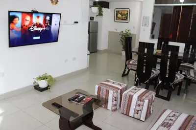 a living room with a table and chairs and a tv at Cusco Perú Apartment in Cusco