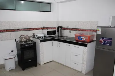 a small kitchen with a stove and a refrigerator at Cusco Perú Apartment in Cusco