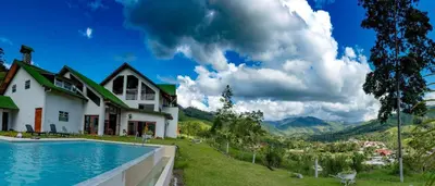 a house with a swimming pool next to a mountain at Göttlich Boutique Hotel in Pozuzo
