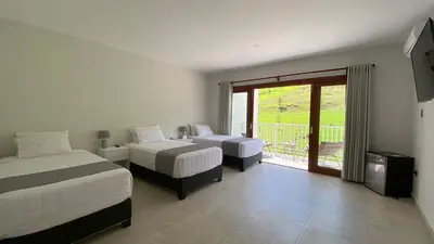 a bedroom with two beds and a balcony at Göttlich Boutique Hotel in Pozuzo