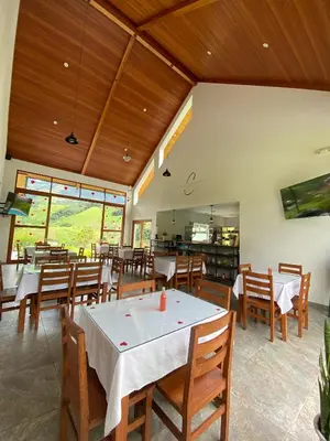 a restaurant with wooden ceilings and tables and chairs at Göttlich Boutique Hotel in Pozuzo