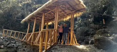 two people standing on a wooden bridge at EcoLodge Mayu Camping in Tanca