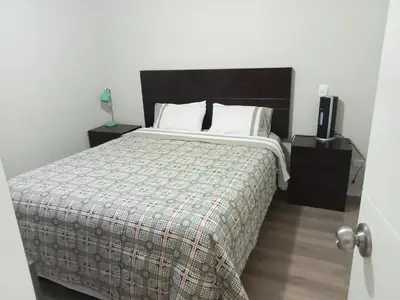 a bedroom with a bed with a blanket and a speaker at Lindo mini apart Pueblo libre Lima in Lima