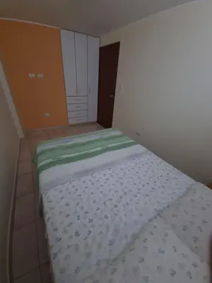 a bedroom with a bed with a green and white comforter at Hermoso Departamento en Pueblo Libre in Lima