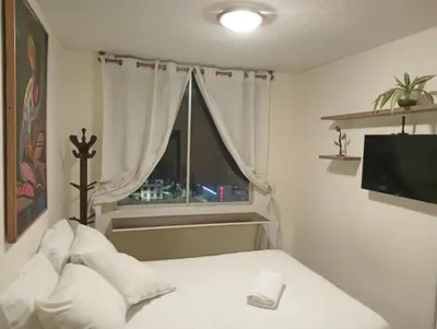 a bedroom with a white bed and a window at Habitación con vista al mar in Lima
