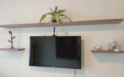a flat screen tv on a wall with shelves at Habitación con vista al mar in Lima