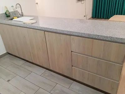 a kitchen counter with wooden cabinets and a sink at Alquiler de habitación en un bonito y cálido departamento muy bien ubicado en Barranco in Lima