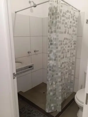 a bathroom with a glass shower with a toilet at Alquiler de habitación en un bonito y cálido departamento muy bien ubicado en Barranco in Lima