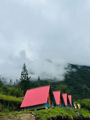 a row of red and blue buildings on a hill at Salkantay Lodge Collpapampa in Colcapampa