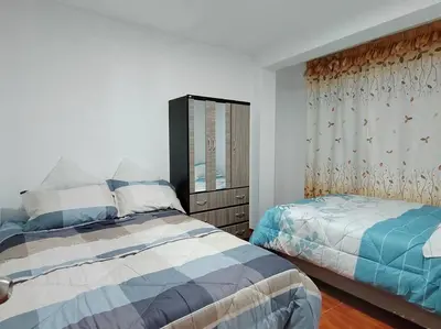 a bedroom with two beds and a dresser at Apartamento de Kelita in Ayacucho