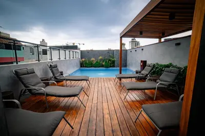 a wooden deck with chairs and a swimming pool at Beautiful and Well Located in Lima