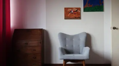 a blue chair sitting next to a wooden dresser at Penthouse in the centre of Miraflores in Lima