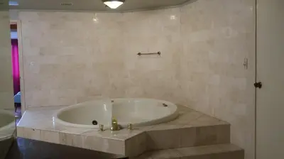 a bath tub in a bathroom with a stone wall at Penthouse in the centre of Miraflores in Lima