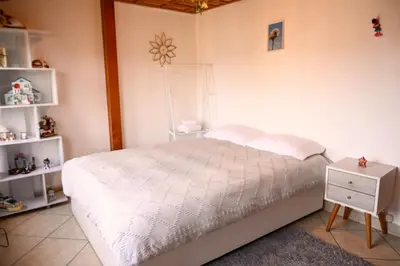 a bedroom with a white bed and a night stand at Gran Olivar Suite de San Isidro -3 Habitaciones in Lima