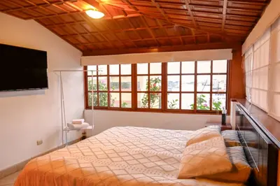 a bedroom with a bed and a large window at Gran Olivar Suite de San Isidro -3 Habitaciones in Lima