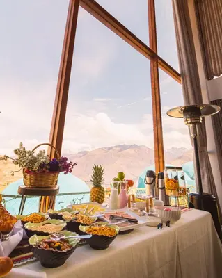a table with food on it in front of a window at Memorable Sacred Experience in Cusco