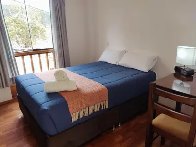 a bedroom with a blue bed with a towel on it at Anata Hotel in Cusco