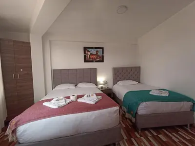 a hotel room with two beds with towels on them at Templo Home in Cusco