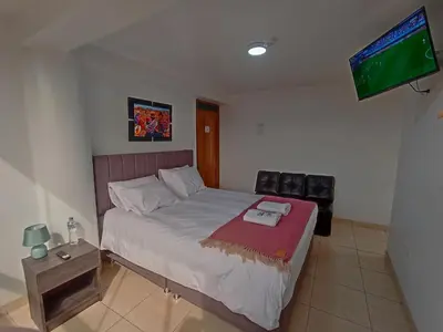 a bedroom with a bed and a flat screen tv at Templo Home in Cusco