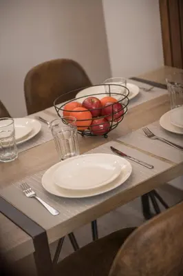 a table with plates and a bowl of fruit on it at Cozy modern heart of city in Cusco