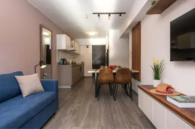 a living room with a blue couch and a table at Cozy modern heart of city in Cusco
