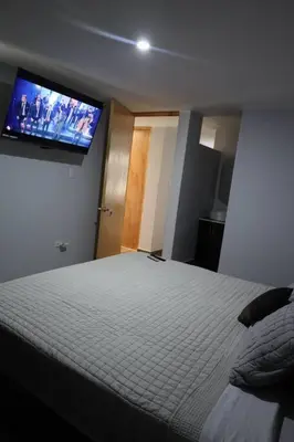 a bedroom with a bed and a flat screen tv at Casa sabina aeropuerto entera in Lima