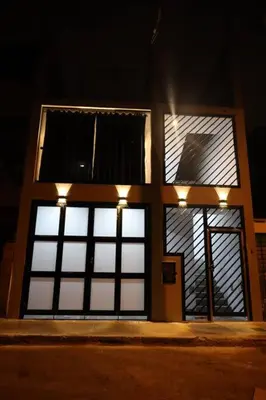 a building with four windows with lights on it at Casa sabina aeropuerto entera in Lima