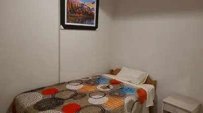 a small bedroom with a bed with a picture on the wall at Samay Ñawi Wasi in Cusco