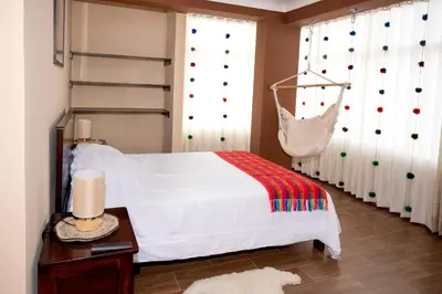 a bedroom with a bed and a hammock at Vive Chinchero in Ayarmaca