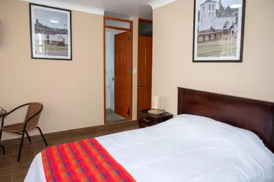 a bedroom with a bed and a chair and a mirror at Vive Chinchero in Ayarmaca