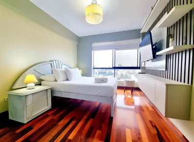 a bedroom with a white bed and a large window at FlatTOP San Isidro City View Lima 3B 1804 in Lima